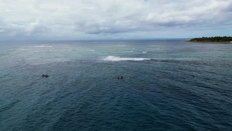 Aerial-orbit-of-fishermen-riding-on-traditional-bangka-boats-in-rough-ocean-waters-during-daytime