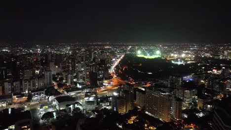 Aerial-View-of-Santo-Domingo,-Dominican-Republic-at-Night,-Busy-Avenue-Traffic,-Shiny-Buildings-and-Lights