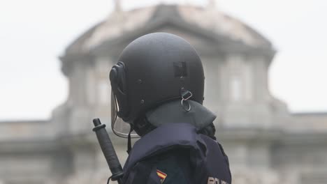 A-police-officer-stands-guard-as-Spanish-farmers-and-agricultural-unions-gather-at-Plaza-de-la-Independencia-to-protest-against-unfair-competition,-agricultural-and-government-policies