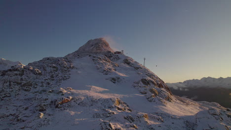 Vista-Aérea-De-La-Cumbre-De-La-Montaña-Rocosa-De-Bettmerhorn-Cubierta-De-Nieve-En-La-Temporada-De-Invierno,-Zona-Del-Glaciar-Aletsch-En-Suiza