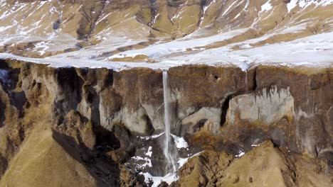 Un-Dron-4k-Captura-Impresionantes-Imágenes-Aéreas-De-Un-Acantilado-Rocoso-Islandés,-Acentuado-Por-Cascadas-Para-Un-Espectáculo-Verdaderamente-Cinematográfico.