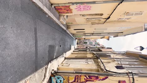 Vertical-shot-of-alley-with-street-art-in-Le-Panier-in-Marseille