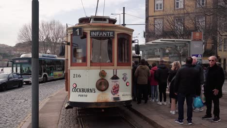 Historische-Straßenbahn-In-Porto-Erwartet-Passagiere-An-Der-Haltestelle-Am-Flussufer-Für-Eine-Landschaftlich-Reizvolle-Stadtrundfahrt-Entlang-Der-Malerischen-Uferpromenade