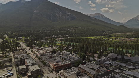 Banff-AB-Canada-Aerial-v35-drone-flyover-town-center-across-glacier-fed-Bow-river-capturing-picturesque-townscape-and-landscape-of-mountain-ranges-in-summer---Shot-with-Mavic-3-Pro-Cine---July-2023