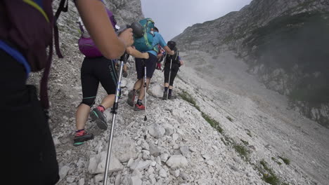 Triglav-Se-Cierne-Delante-Mientras-Los-Excursionistas-Recorren-Senderos-Rocosos,-Avanzando