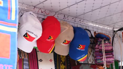 Close-up-of-a-selection-of-colorful-baseball-cap-gifts-and-souvenirs-at-tourism-Tais-market-in-capital-city-of-East-Timor,-Southeast-Asia