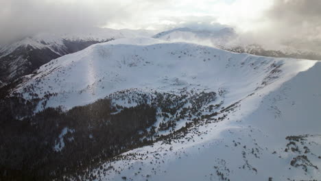 High-Elevation-Berthoud-Pass-Winter-Park-scenic-landscape-view-aerial-drone-backcountry-ski-snowboard-Berthod-Jones-afternoon-sunset-Colorado-Rocky-Mountains-peaks-forest-forward-pan-up-reveal-motion