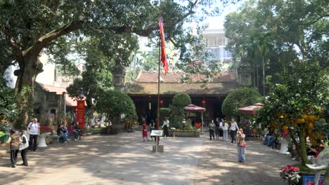 Quan-Thanh-Temple-entrance-with-visitors-and-traditional-Tet-decorations,-Hanoi,-Vietnam