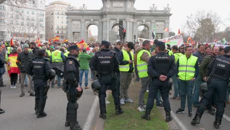 Polizisten-Stehen-Wache,-Als-Sich-Spanische-Landwirte-Und-Agrargewerkschaften-Auf-Der-Plaza-De-La-Independencia-Versammeln,-Um-Gegen-Unlauteren-Wettbewerb,-Agrar--Und-Regierungspolitik-Zu-Protestieren