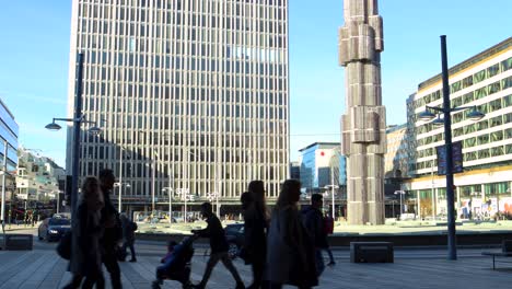 People-walk-by-Sergels-Torg-square-in-Stockholm,-father-with-stroller