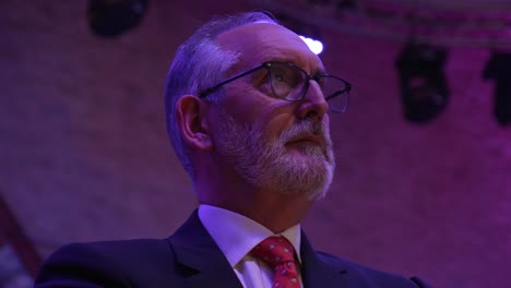 Close-up-shot-of-a-senior-business-man-listening-to-a-presentation-at-a-event