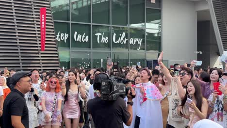 Scene-of-a-cameraman-taking-video-of-the-'Swifties'-happily-singing-and-dancing-outside-the-National-Stadium-in-Singapore-for-Taylor-Swift,-The-Eras-Concert-Tour