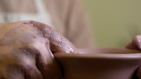 Potter-Moldeando-Suavemente-El-Borde-De-Un-Jarrón-De-Arcilla-Hecho-A-Mano-Con-Una-Esponja-Húmeda-Girando-Sobre-Un-Torno-De-Alfarería