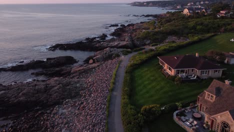 Puesta-De-Sol-Aérea-En-Ogunquit-Maine-Usa,-Drones-Que-Revelan-Un-Pintoresco-Sendero-Costero-Y-Un-Complejo-De-Casas-Frente-Al-Mar