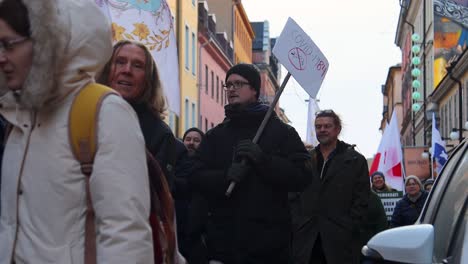 Man-with-Covid-1984-sign-at-vaccine-law-protest-march-in-Sweden,-slomo