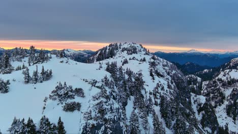 Paisaje-Escénico-De-Montañas-Y-árboles-Nevados,-Colorido-Cielo-Al-Atardecer