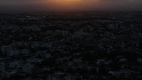 Vista-Aérea-De-Santo-Domingo-A-La-Luz-Del-Sol-De-La-Tarde-Sobre-Las-Nubes,-República-Dominicana,-Disparo-De-Drone