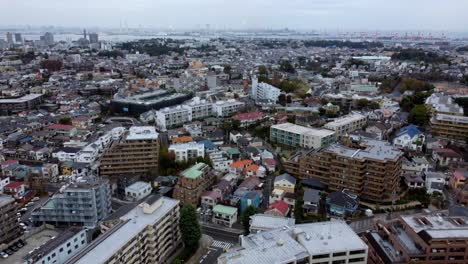 A-dense-cityscape-with-colorful-buildings-and-autumn-trees,-aerial-view