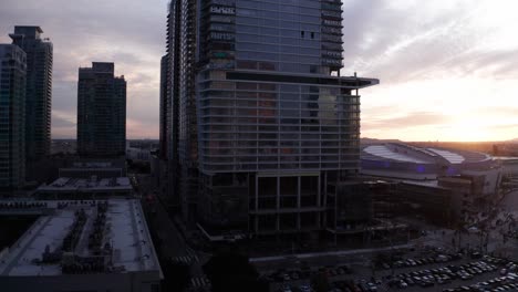 Aerial-wide-rising-shot-of-the-Oceanwide-Plaza-graffiti-buildings-at-sunset-in-downtown-Los-Angeles,-California