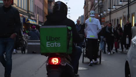 Zeitlupe-Eines-Uber-Eats-Mopeds,-Das-In-Der-Fußgängerzone-In-Stockholm-Fährt