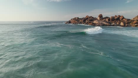 Cape-Town,-South-Africa---Surfers-Relishing-the-Frothy-White-Waves-of-the-Ocean-at-Llandudno's-Coastal-Suburb---Orbit-Drone-Shot