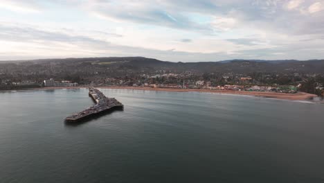 Aerial-drone-shot-flying-in-towards-the-santa-cruz-beach-during-sunset