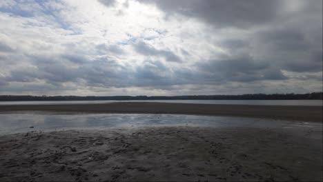 Hungary,-Tata,-the-unloaded-and-empty-Lake-Öreg-during-winter-time-with-soaring-birds-in-the-middle-of-it-on-a-cloudy-day