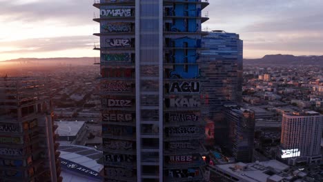 Toma-Panorámica-Aérea-En-Primer-Plano-De-Las-Torres-De-Graffiti-De-Oceanwide-Plaza-En-El-Centro-De-Los-Ángeles,-California-Al-Atardecer