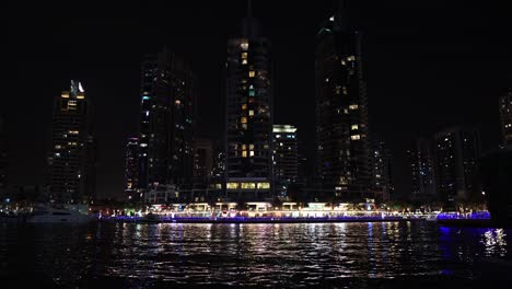Noche-En-Dubai-Marina-Uae,-Reflejo-De-Luz-Sobre-El-Agua-Y-Las-Torres