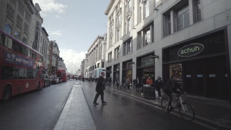 First-person-view-of-double-deck-bus-in-Oxford-street-with-people-walking-along