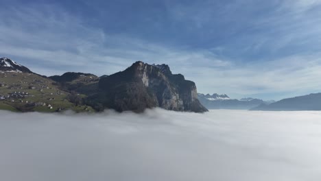 Walensee-peaks-emerge-above-blanket-of-clouds,-Swiss-alps-aerial-panorama