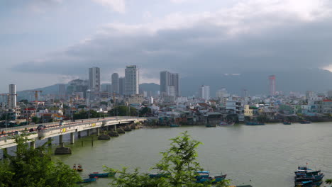 View-of-Traffic-on-Xom-Bong-Bridge-over-Cai-River-and-Nha-Trang-City-Skyline,-Khanh-Hoa-Province,-Central-Vietnam