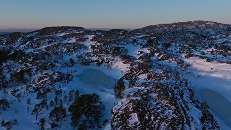 Vista-Aérea-Del-Paisaje-Montañoso-Cubierto-De-Nieve-Cerca-De-Bessaker-En-Trondelag,-Noruega