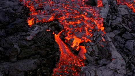 A-4K-drone-captures-a-cinematic-aerial-shot,-offering-a-distinctive-and-extreme-close-up-view-of-cascading-lava-in-slow-motion