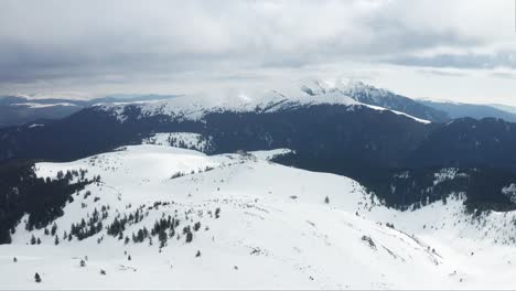 Snow-covered-Ciucas-Mountains-under-cloudy-skies,-expansive-winter-landscape,-daytime