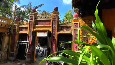 Entrance-to-Guan-Di-Temple-in-Hoi-An,-Vietnam-from-the-inside-courtyard-looking-back-out-with-plants-and-blue-sky