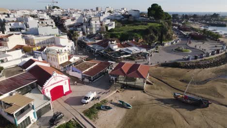 Pueblo-De-Alvor-Durante-La-Marea-Baja-Con-Un-Sereno-Paseo-Marítimo,-Algarve-Portugal---Antena