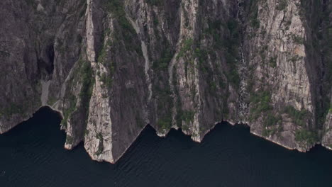 Aerial-shot,-pushing-in-on-the-cliffs-beneath-Preikestolen,-by-Lysefjord-in-Norway