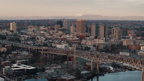 Heavy-traffic-passes-along-the-I5-bridge-near-the-University-of-Washington-campus-in-Seattle,-Washington-against-a-mountain-backdrop