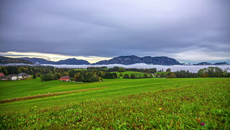 Low-angle-static-shot-of-cloudscape-passing-over-scattered-houses-in-Austrian-alpine-region