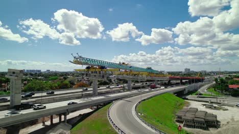 Aerial-overview-launching-Gantry-segmental-bridge-construction-setup-over-Dolphin-Expressway,-Miami,-Florida,-USA