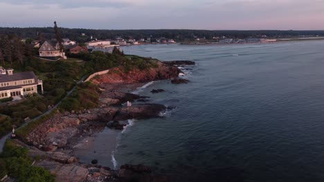 golden-hours-scenic-coastline-in-Ogunquit-Maine-USA-drone-fly-above-rocky-cliff-seascape-and-waterfront-oceanside-resort-house