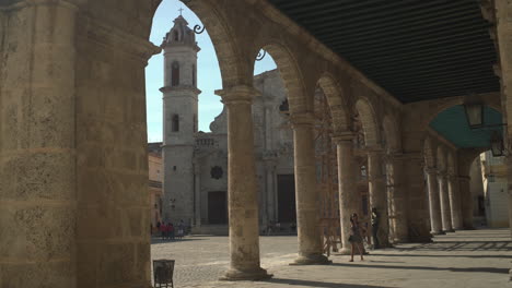 Ein-Einzigartiger-Blickwinkel-Auf-Die-Plaza-Vieja-Bietet-Einen-Blick-Auf-Die-Kathedrale-Von-Havanna,-Während-Ein-Tourist-Spazieren-Geht-Und-Die-Architektur-Bewundert