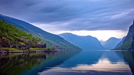 Majestic-fjord-landscape-in-Norway-at-dusk-with-serene-waters-and-mountain-backdrop,-timelapse