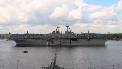 Huge-military-ship-USS-Kearsarge-in-still-water-on-cloudy-day,-static