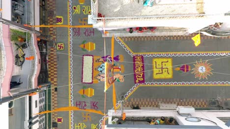 Luftaufnahme-Einer-Drohne-In-Richtung-Der-Stelle,-An-Der-Große-Rangolis-Auf-Die-Straße-Gemalt-Sind-Und-Menschen-Rangoli-Für-Das-Wohngebäude-Jai-Siyaram-Malen,-Ist-Sichtbar
