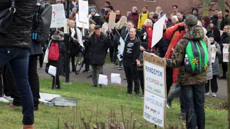 Crowd-of-protesters-with-signs-at-Covid-restriction-rally-in-park
