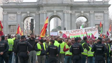 Polizisten-Stehen-Wache,-Als-Sich-Spanische-Landwirte-Und-Agrargewerkschaften-Auf-Der-Plaza-De-La-Independencia-Versammeln,-Um-Gegen-Unlauteren-Wettbewerb,-Agrar--Und-Regierungspolitik-Zu-Protestieren