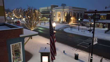 American-flag-in-snow-covered-American-town-during-winter,-Christmas-time