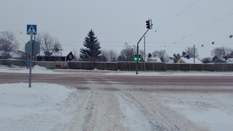 Driving-on-a-green-light-and-turning-at-an-intersection-in-winter-conditions-with-snow-on-the-road